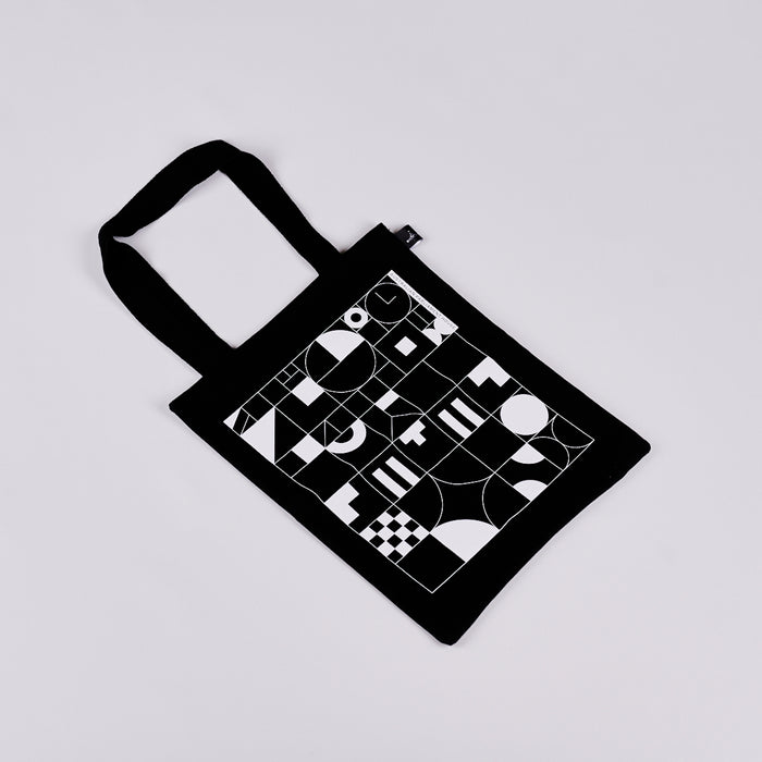 Black tote bag featuring a black and white geometric design.