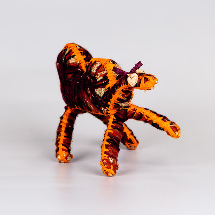 Grass woven camel sculpture in red and orange.