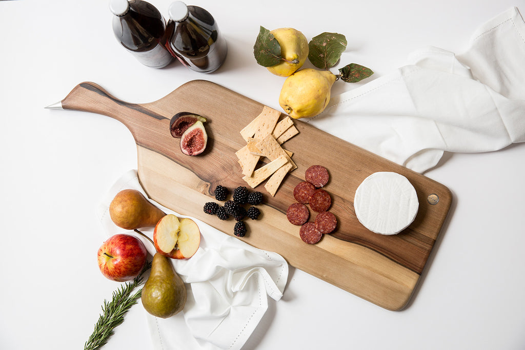 Wooden board with cheese and antipasto on top