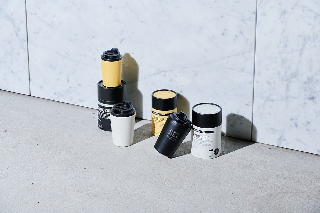 Three Fressko Parliament Shop branded cups sitting on concrete with a white marble background.
