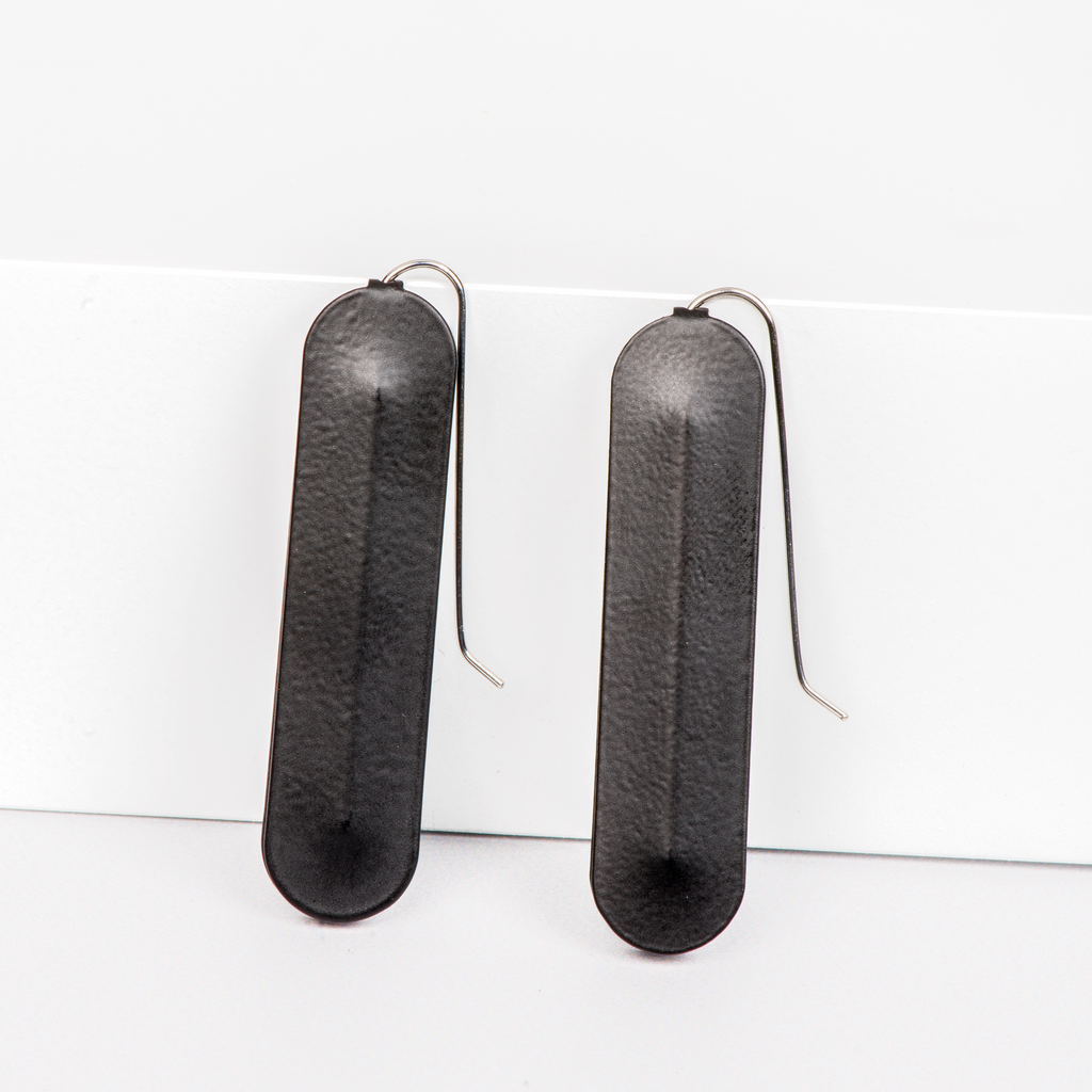 Dangle earrings featuring long black oval pendants