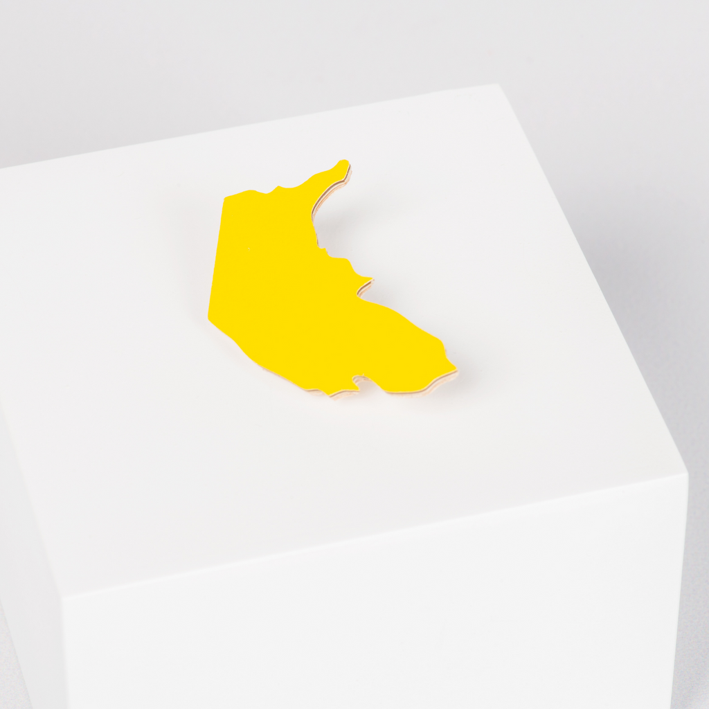 Wooden yellow brooch in the shape of the Australian Capital Territory 