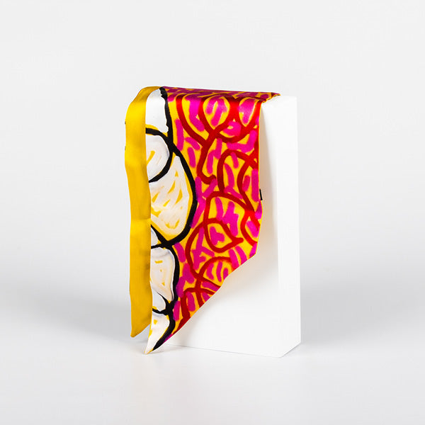 vibrant silk scarf hanging from white plinth