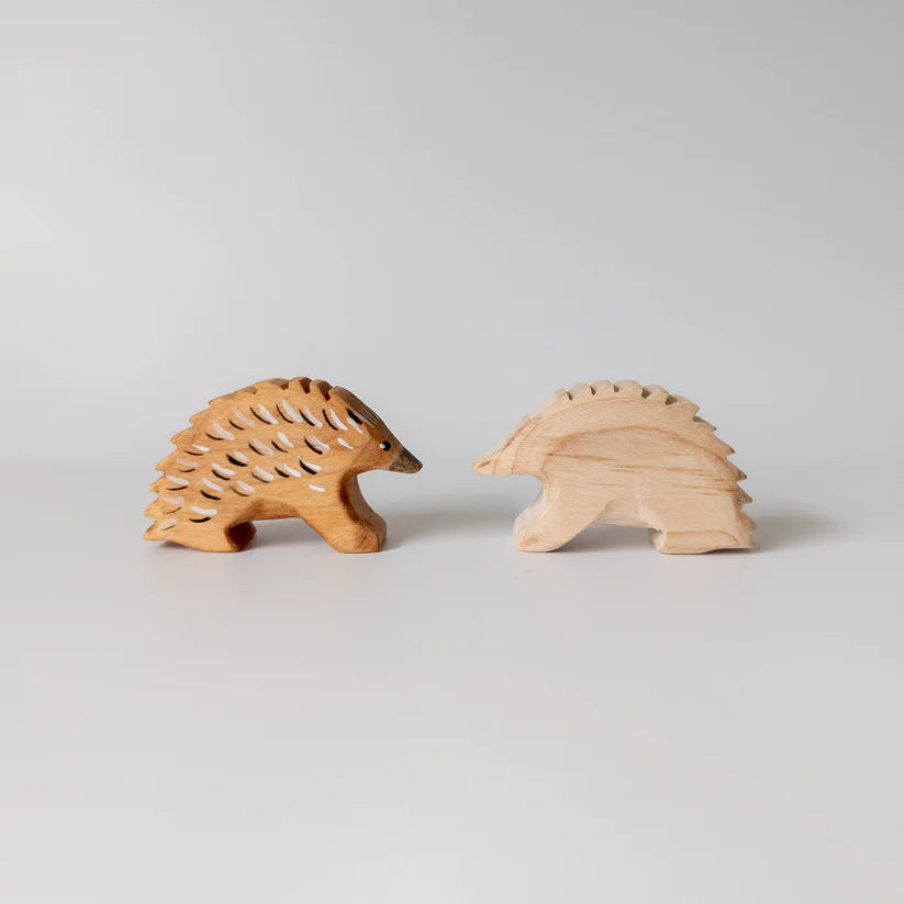 two small wooden echidna toys facing each other