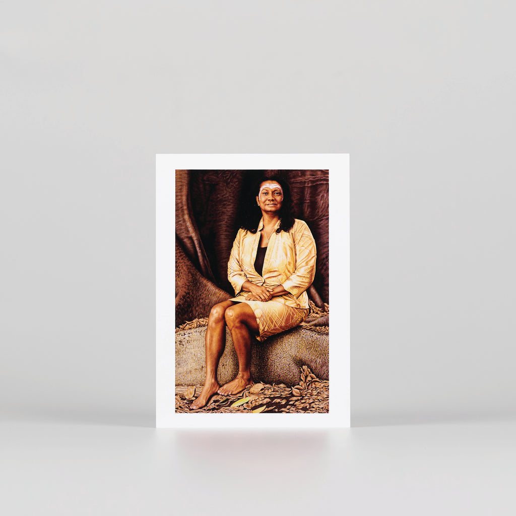 postcard of a portrait of Nova Peris OAM sitting on tree bark staring directly at us