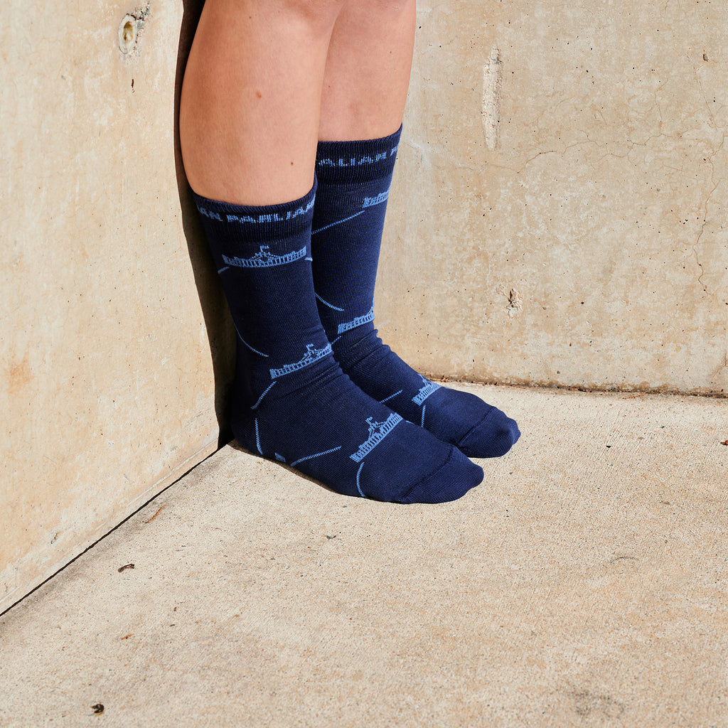 Navy socks with repeated, light blue Parliament House logos on a pair of women's feet.