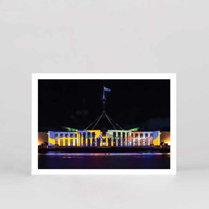 postcard of australian parliament house illuminated in colourful patterns 