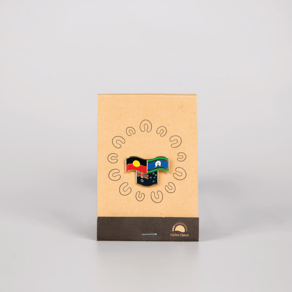 lapel pin of aboriginal, Torres strait islander and Australian flags on brown backing card