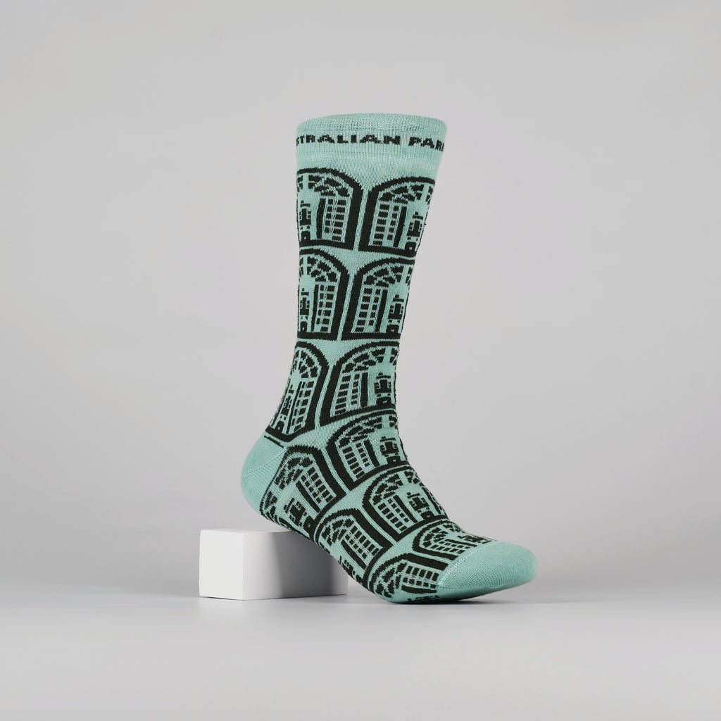 green sock with repeated, dark green house of representative logos on a foot mannequin