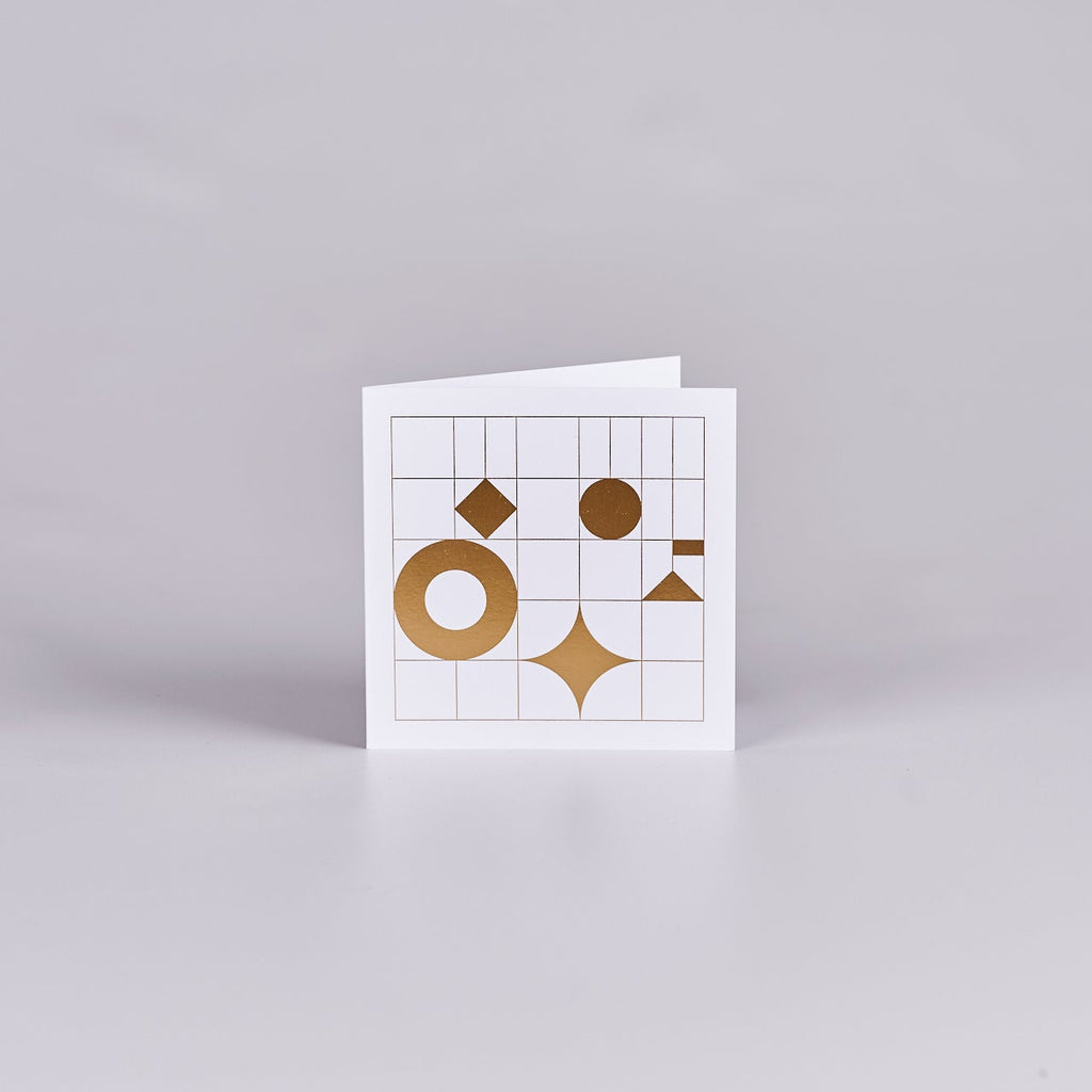 White card with a grid design and gold shapes. 