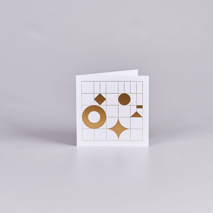 White card with a grid design and gold shapes. 