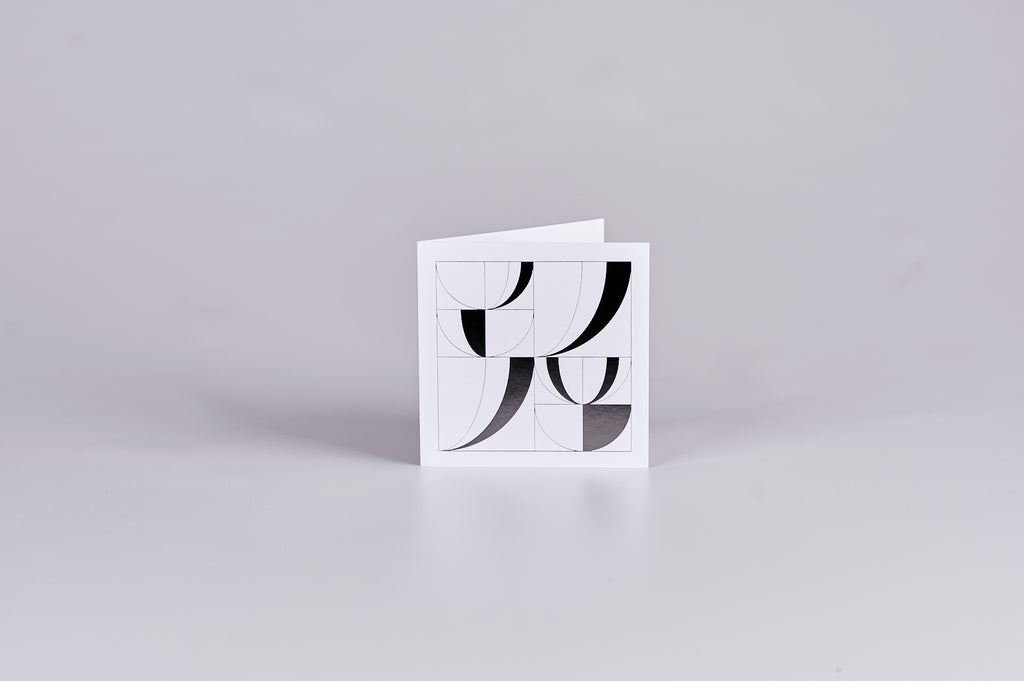 White square gift card with a black geometric design in the shape of open books.