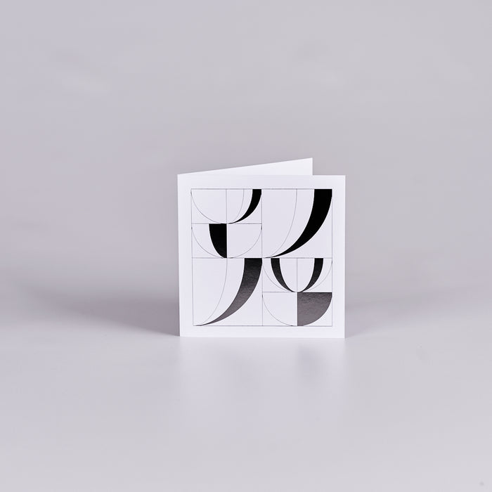 White square gift card with a black geometric design in the shape of open books.