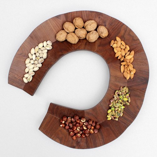 wooden serving dish with a V shape design holding variety of nuts