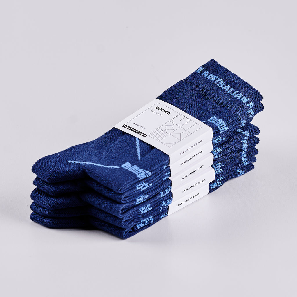 Five pairs of packaged navy socks in a pile.