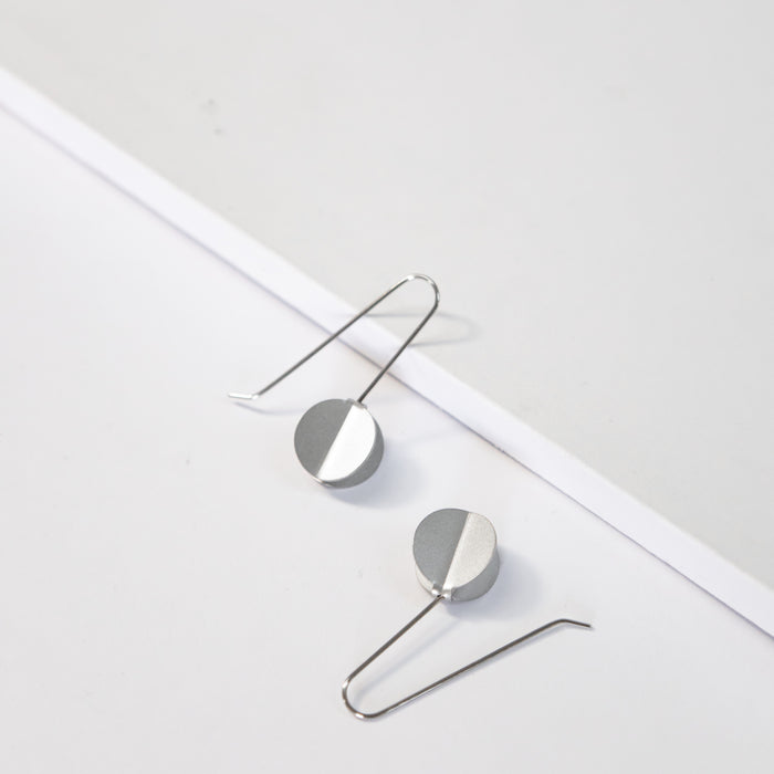 Dangle earrings featuring folded dot pendants