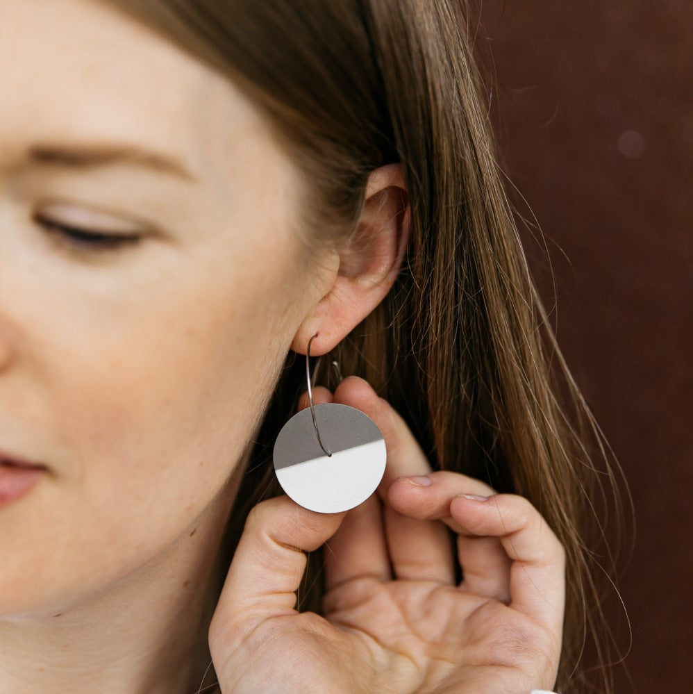 Woman wearing Round folded disc earrings in simple modern style