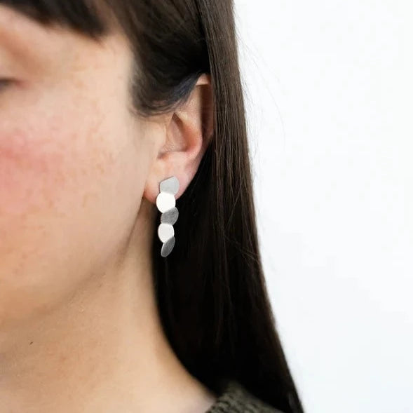 woman wearring Minimalist stainless steel earrings featuring a line of circles