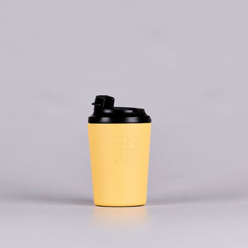 Yellow reusable coffee cup with black geometric design. 