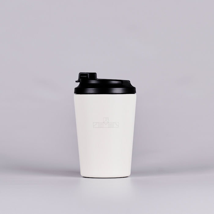 White reusable coffee cup with black geometric logo inspired by the Parliament House building. 