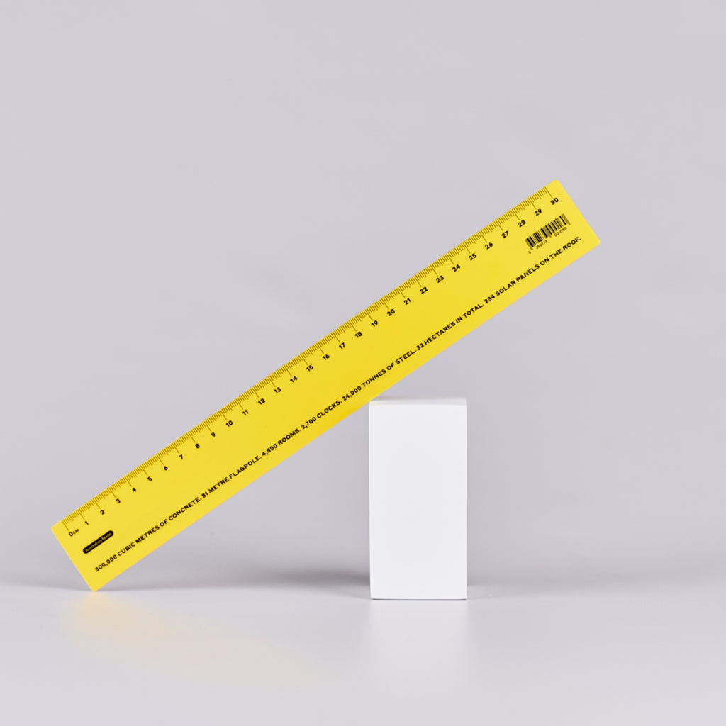 Yellow ruler with black numbers and text with statistics relating to Parliament House. There are 2,700 clocks.