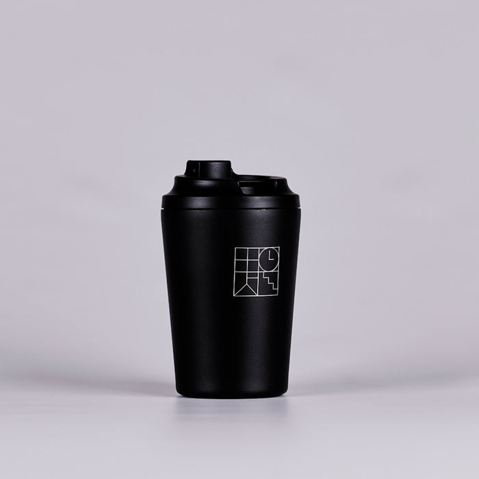 Black reusable coffee cup with white geometric design. 