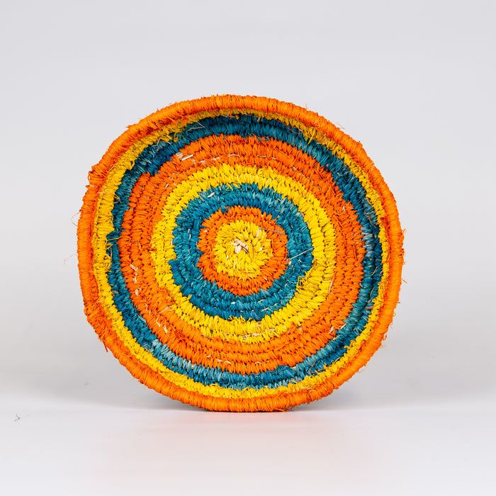 Inside of grass woven basket in orange, blue and yellow colours.