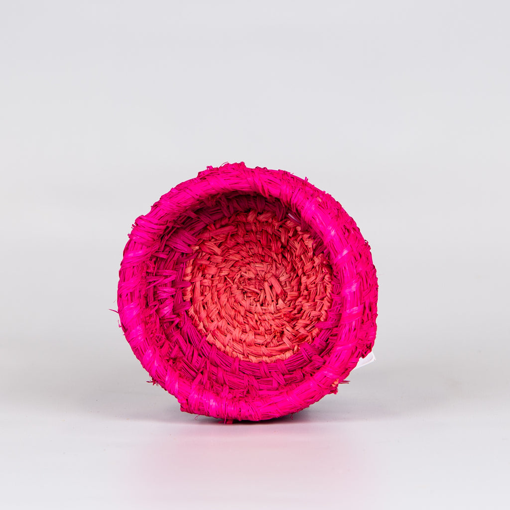 Inside of grass woven basket in pink colours.