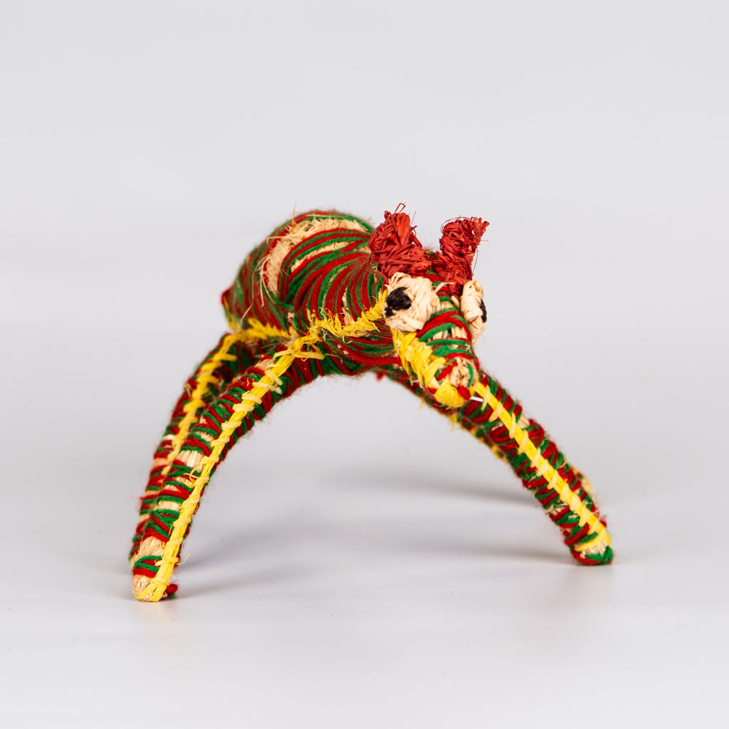 Grass woven camel sculpture in red, green and yellow.