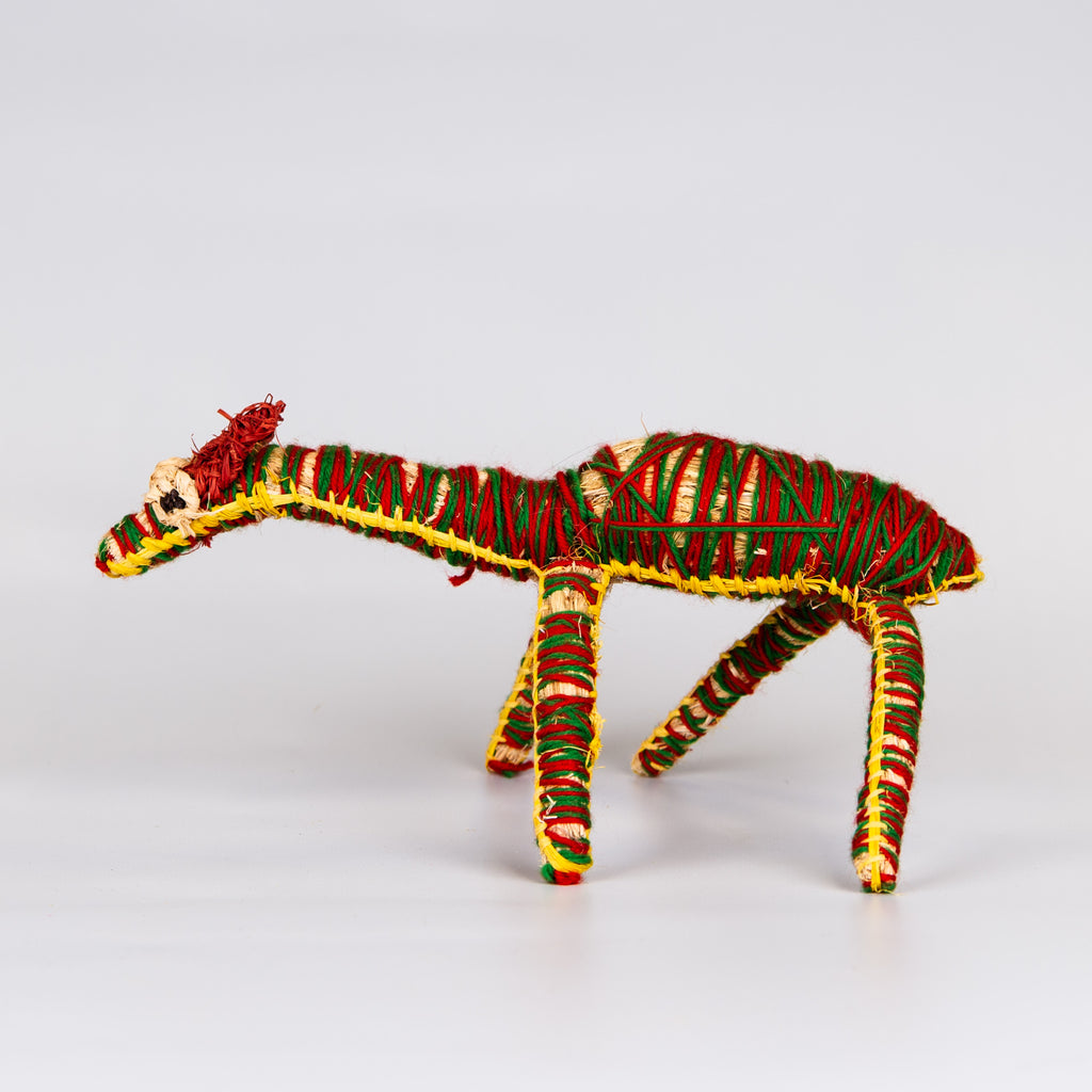 Grass woven camel sculpture in red, green and yellow.