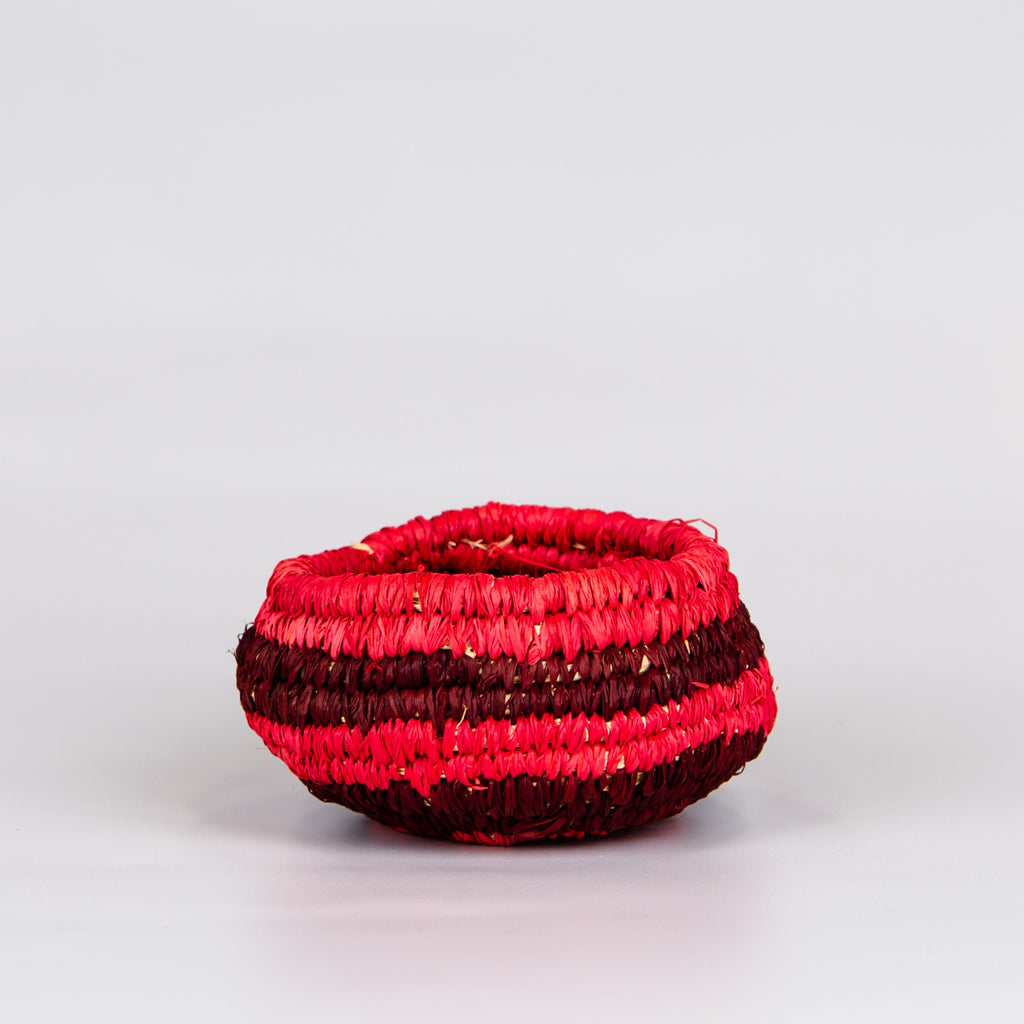 Side of grass woven basket in red.