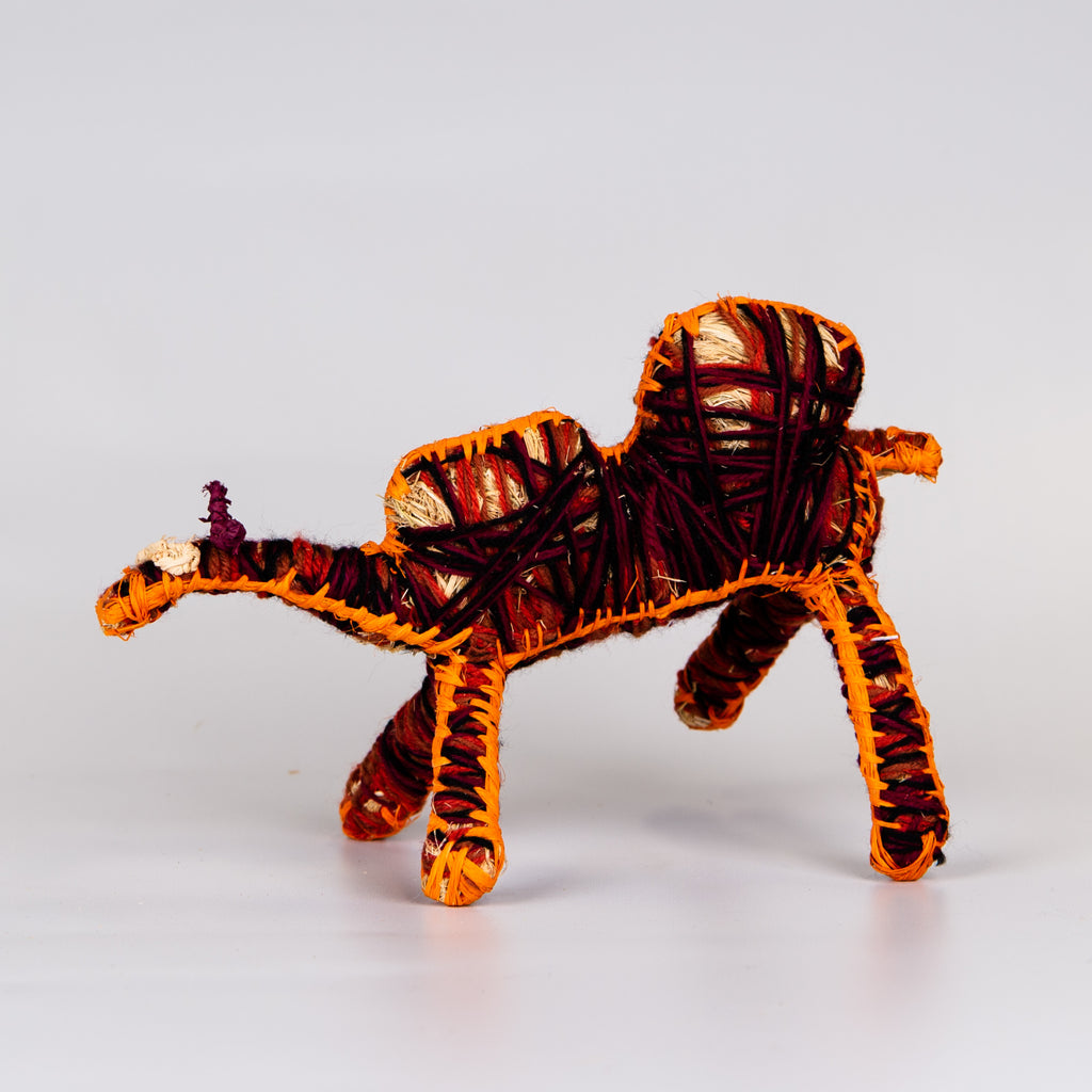 Grass woven camel sculpture in red and orange.