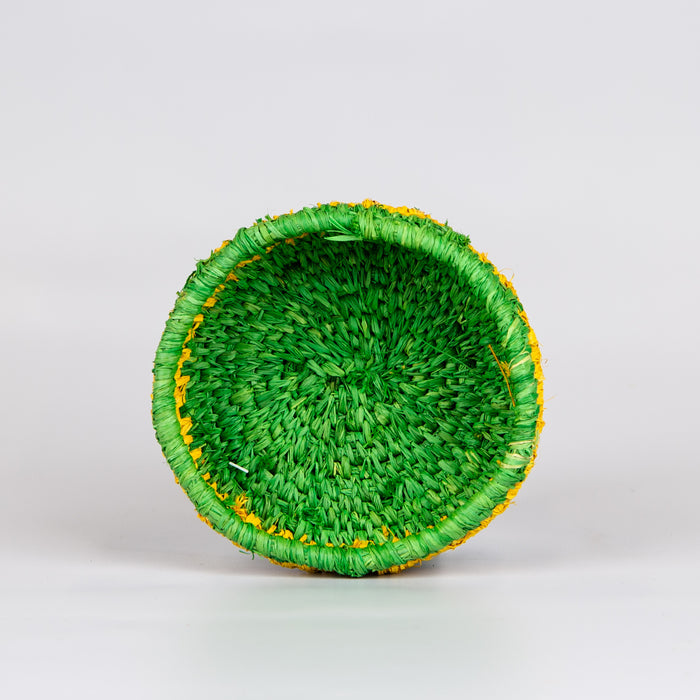 Inside of grass woven basket in green and yellow colours.
