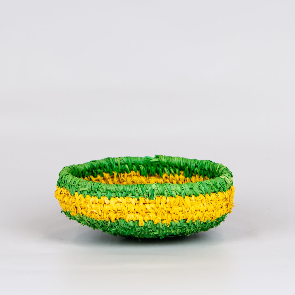Side of grass woven basket in yellow and green colours.