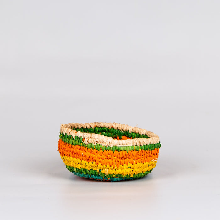 Side of grass woven basket in orange, yellow and green colours.