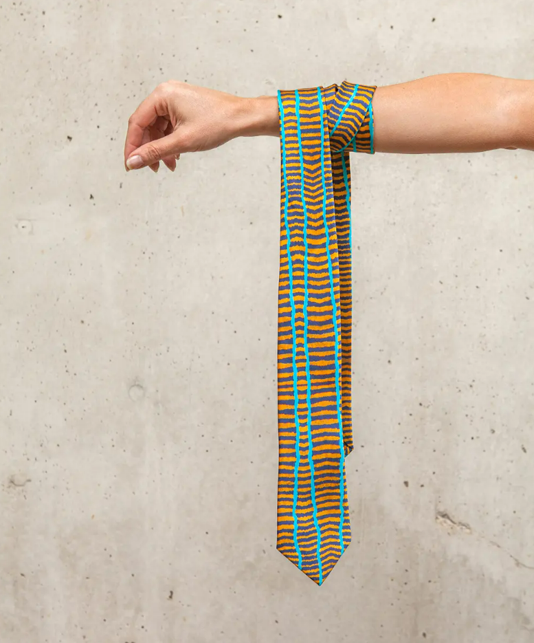 a tie rolled and hanging from an arm