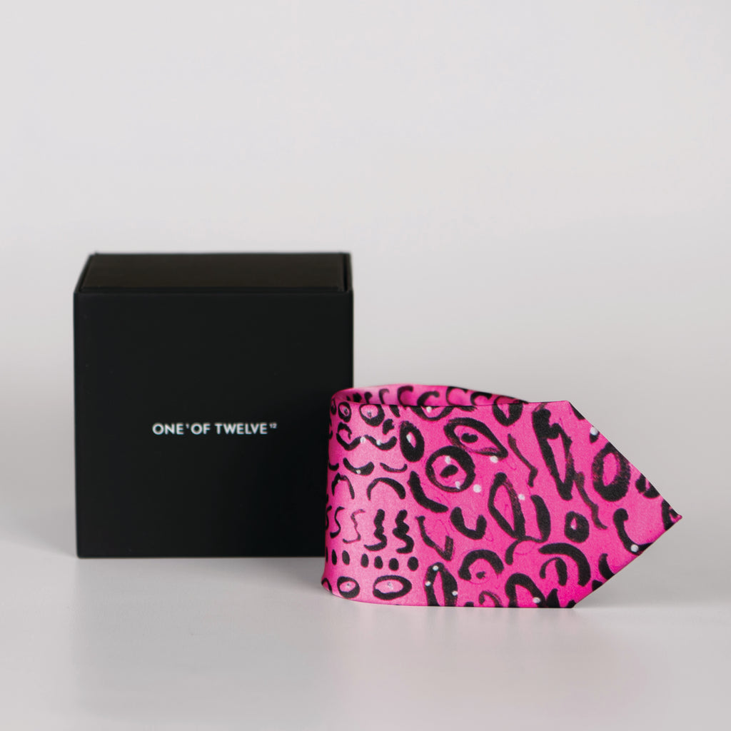 a rolled hot pink tie with black spot detail and a black display box
