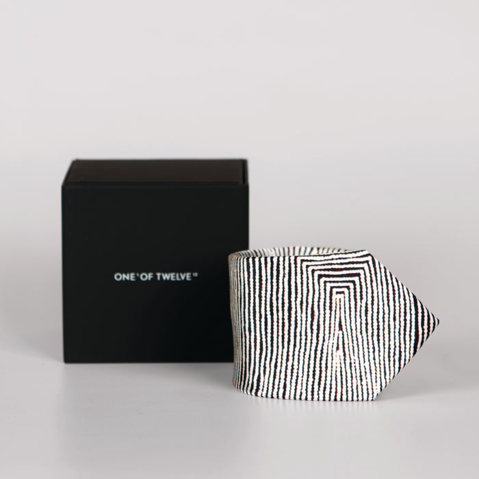 a rolled black and white tie and a display box